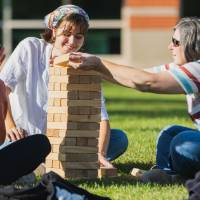 Family playing with Jenga blocks on Kirkhof Lawn.